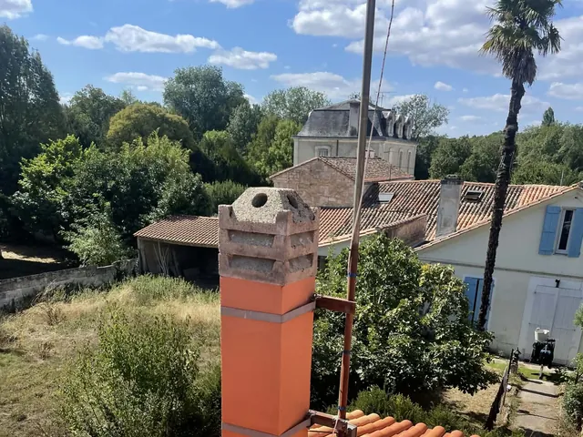 Souche de cheminée neuve avec mitron sur toiture en tuiles canal, vue en plongée, chantier Artisan JP